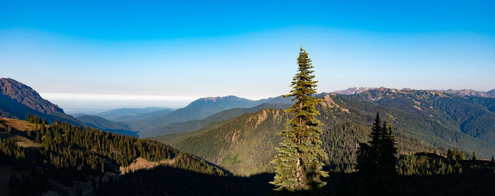 Scenic view of mountains against blue sky