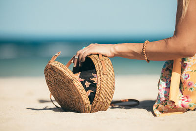 Midsection of woman holding seashell at beach