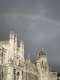 Buildings against sky with rainbow in background