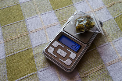 High angle view of marijuana with weight scale on table