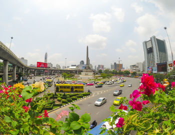 View of street amidst buildings against cloudy sky