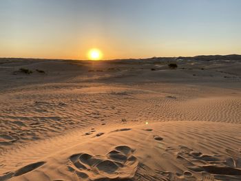 Scenic view of desert against sky during sunset