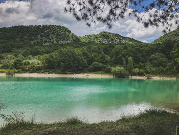 Scenic view of lake by mountains against sky