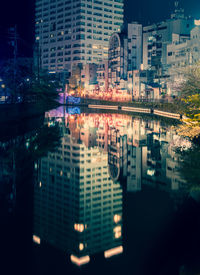 Reflection of illuminated buildings in city at night