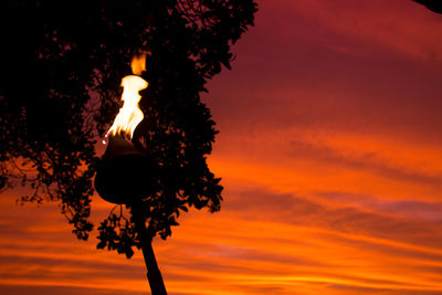 Low angle view of illuminated street light against orange sky