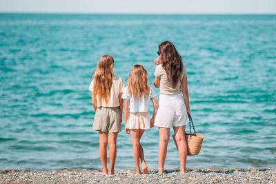 Rear view of women standing on beach