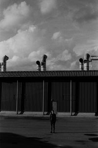 Low angle view of people walking on street against sky