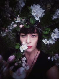 Portrait of beautiful woman with red flowers