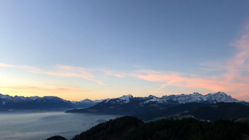 Scenic view of snowcapped mountains against sky during sunset