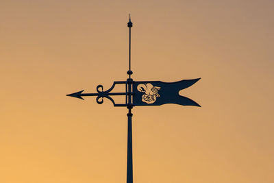 Low angle view of weather vane against clear sky