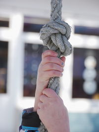 Cropped hand of person holding rope