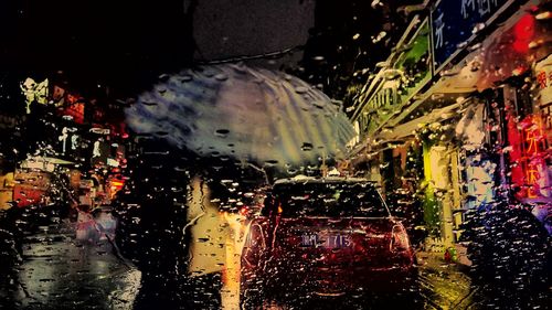 Water drops on car windshield in city during rainy season