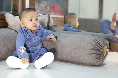 Cute boy sitting on sofa at home