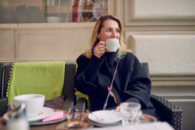 Young woman drinking coffee at restaurant