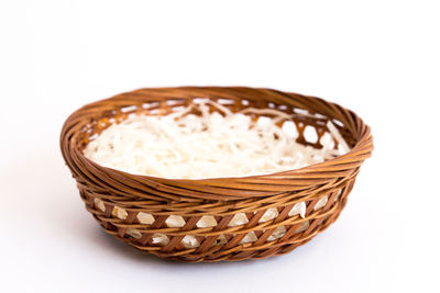 Close-up of bread in basket against white background