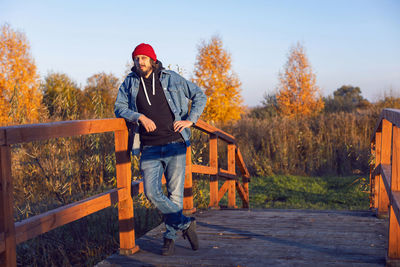 Portrait of a village man stands on a bridge in the village in autumn