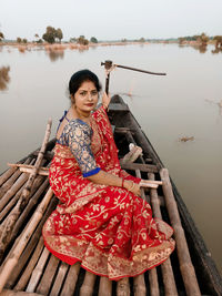 Portrait of young woman sitting on pier