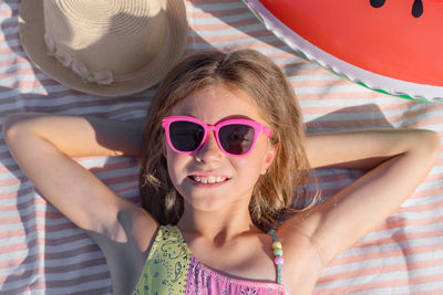 Portrait of a happy child on a beach towel with glasses. top view.