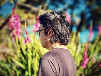 Side view of woman standing amidst plants