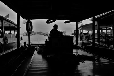 Rear view of silhouette people sitting in boat