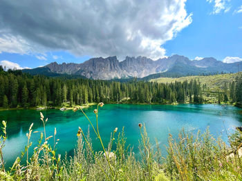 Scenic view of lake by mountains against sky