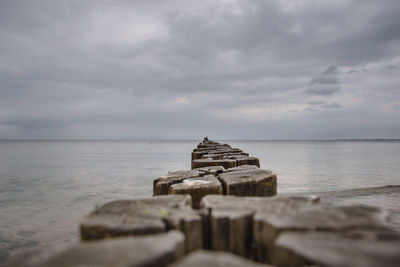 Groyne by sea against sky