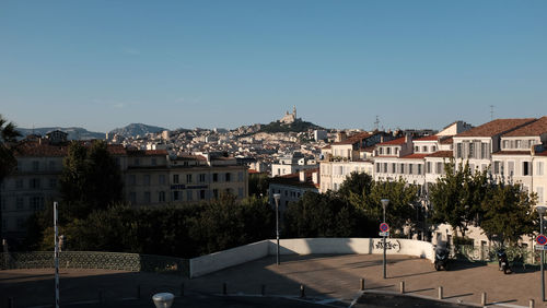 Buildings in city against clear blue sky