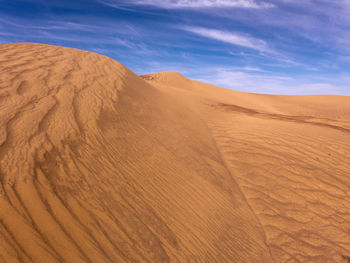 Scenic view of sand dunes in desert against sky