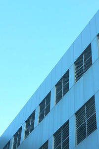 Low angle view of modern building against clear blue sky