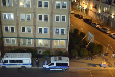 High angle view of cars on street by buildings at night