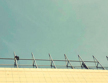Low angle view of railing by building against clear sky