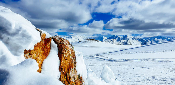 Snow covered landscape against sky