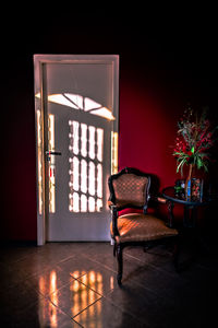 Empty chair by closed door in living room at home