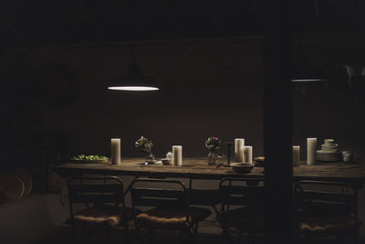 Dining table with candles in illuminated room