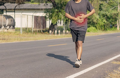 Full length of man skateboarding on road