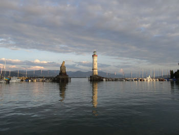 Lighthouse by sea against sky