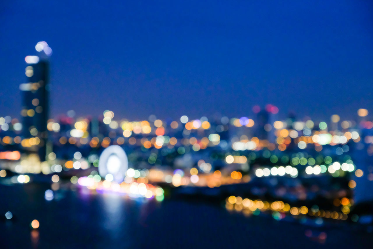 DEFOCUSED IMAGE OF ILLUMINATED CITY AT NIGHT