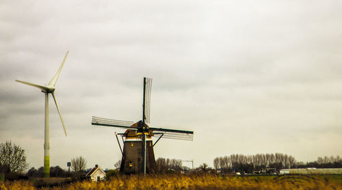 Traditional windmill on field against sky