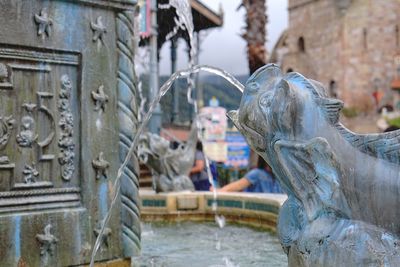 Water flowing from sculpture in fountain