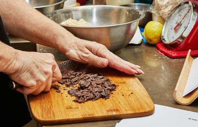 Chef cuts the chocolate with knife to make chocolate cake