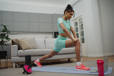 Portrait of young woman exercising at home