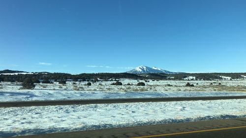 Scenic view of snowcapped mountains against clear blue sky