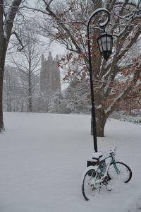 Bicycle by street lamp on snow covered field