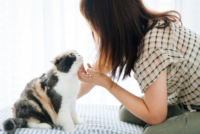 Midsection of woman sitting on sofa at home