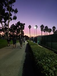 People walking on footpath at park against sky