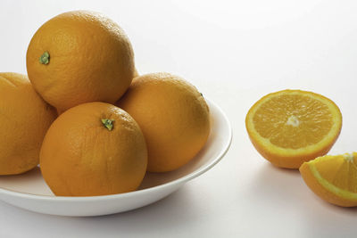 Close-up of fruits in plate against white background