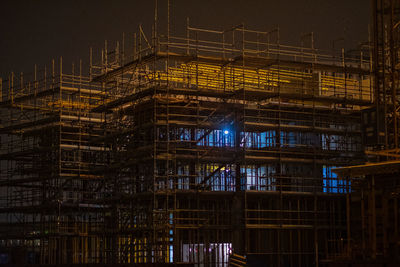 Low angle view of illuminated construction site at night