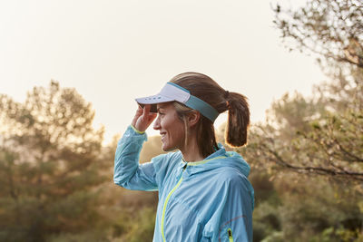 Happy woman adjusting visor cap