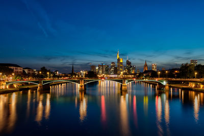 Illuminated bridge over river at night