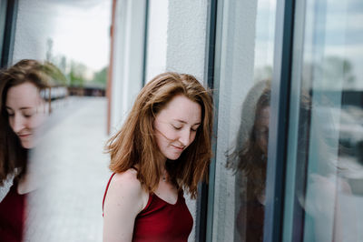 Woman standing by glass window